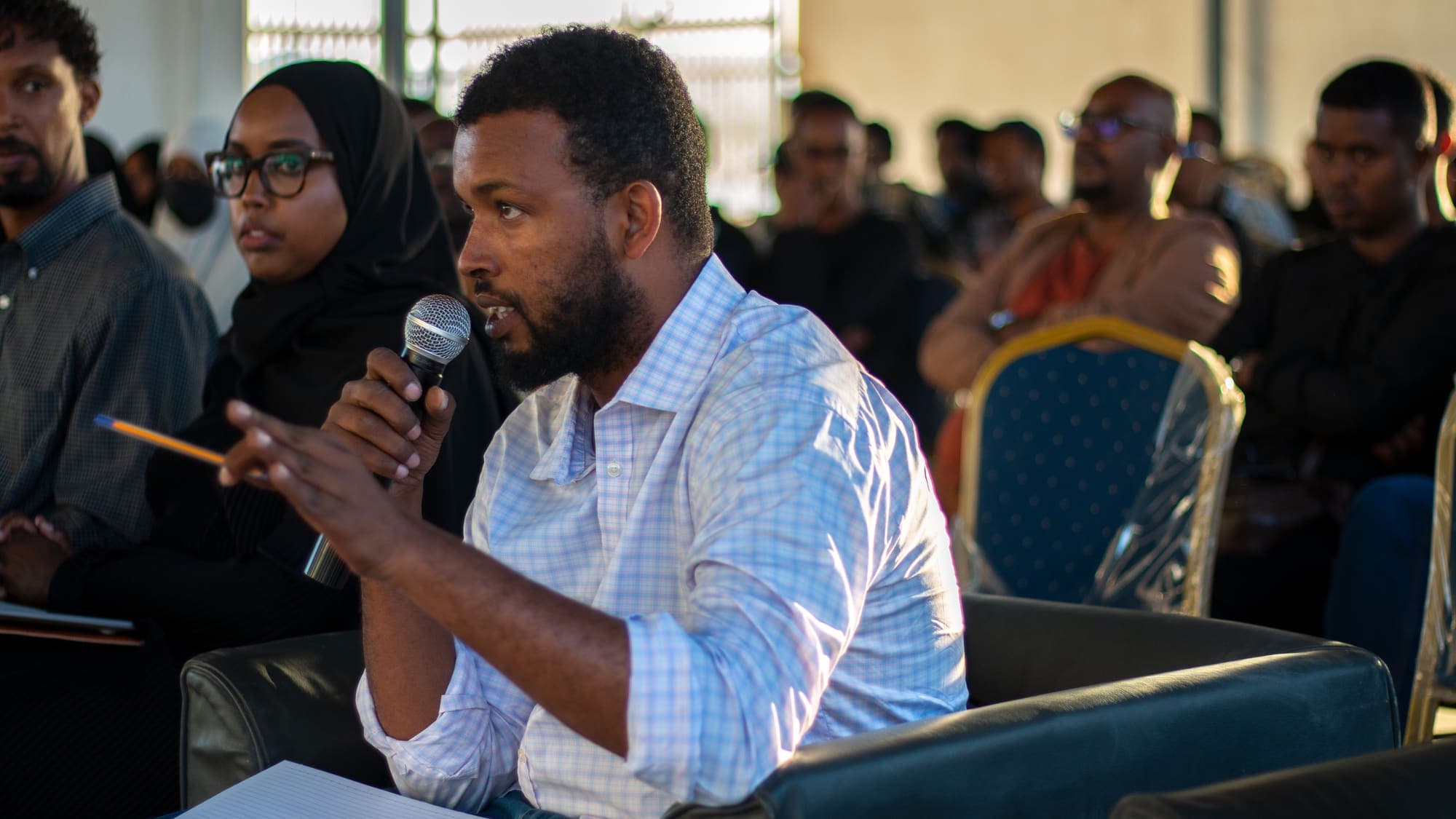 A man in the audience speaks into a microphone