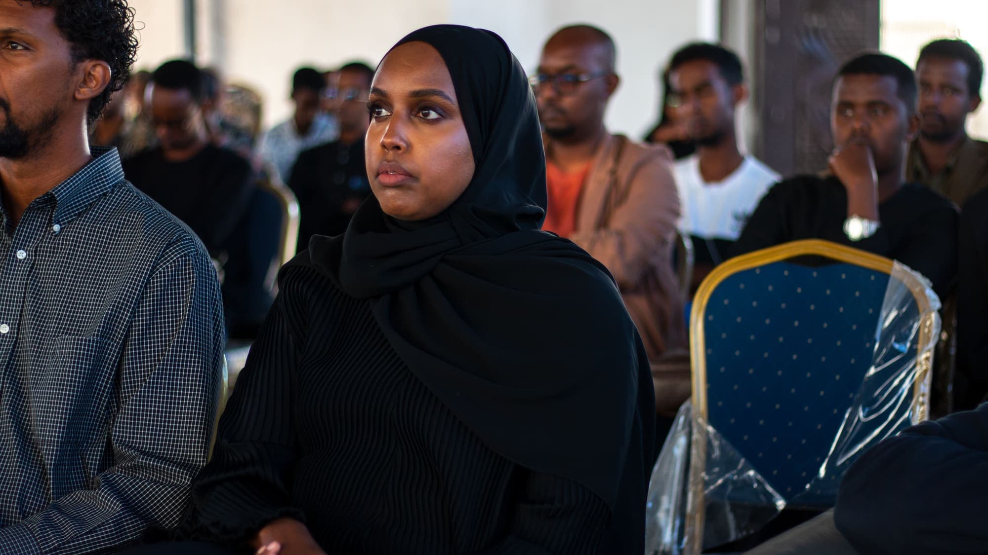 A woman in the audience follows the session