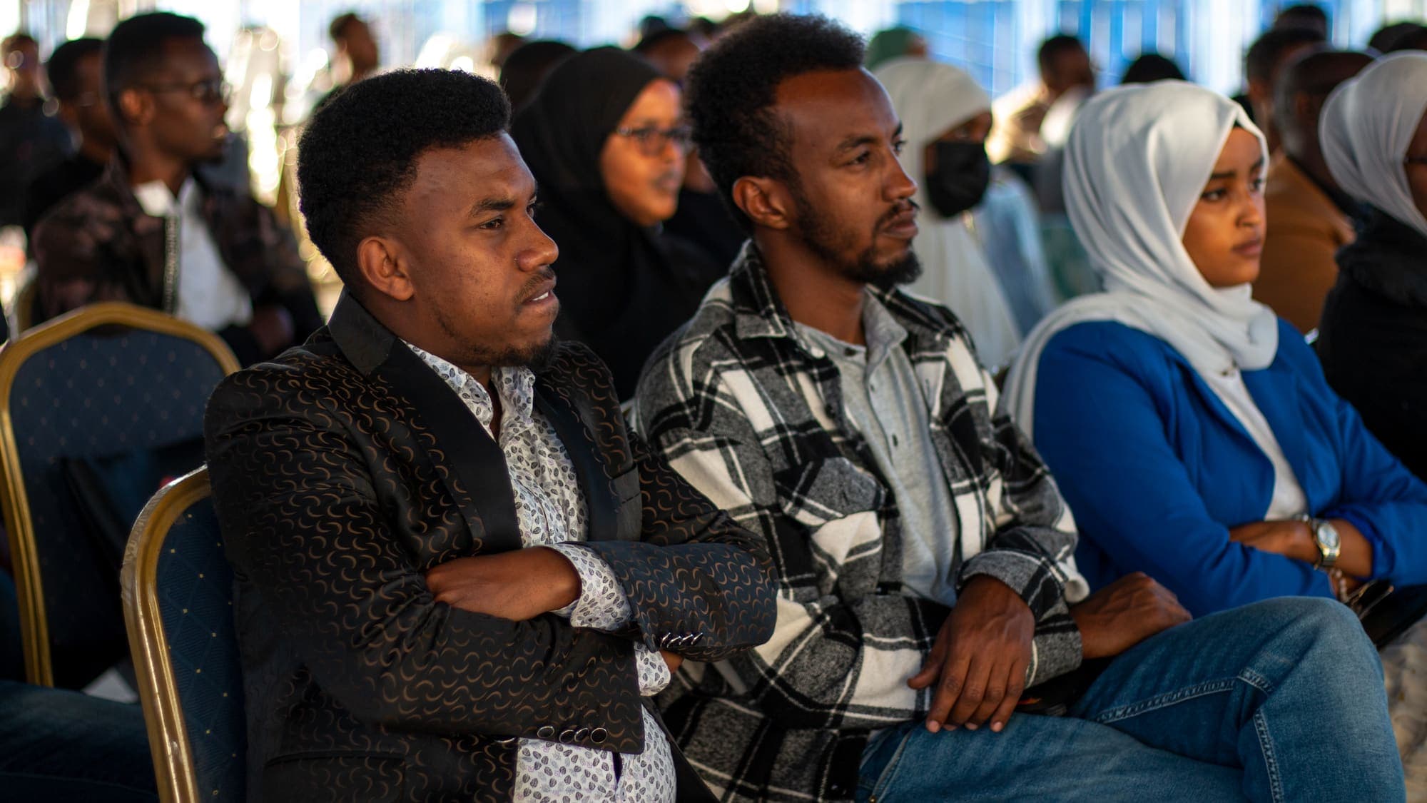 Three people seated side by side in the audience