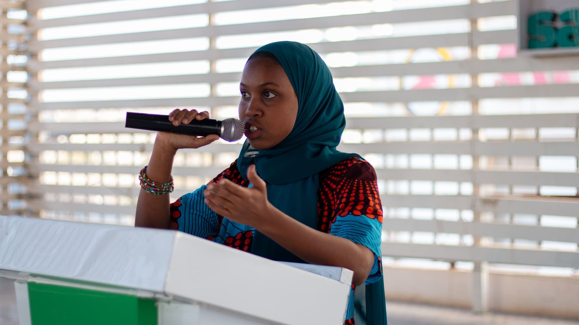 A woman speaks into a microphone at the podium