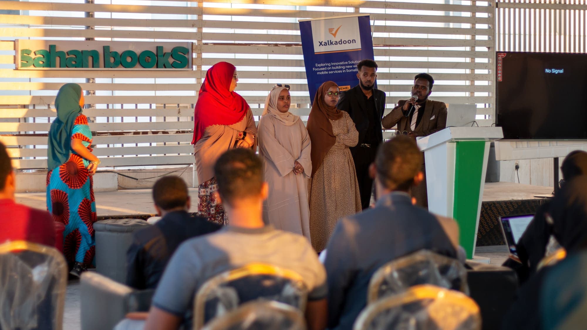 A group stands together on stage in front of the audience