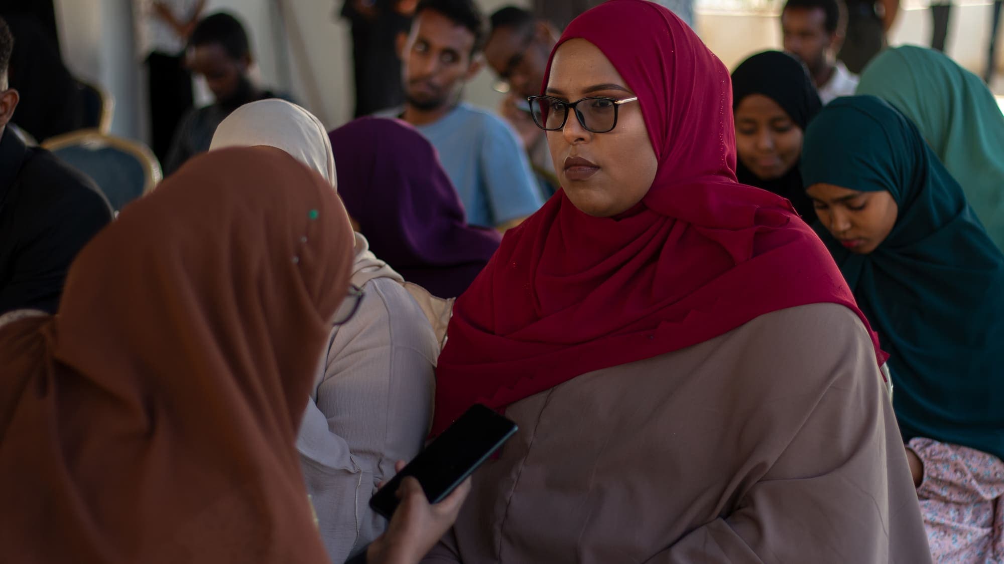 Women in the audience turn to talk with each other