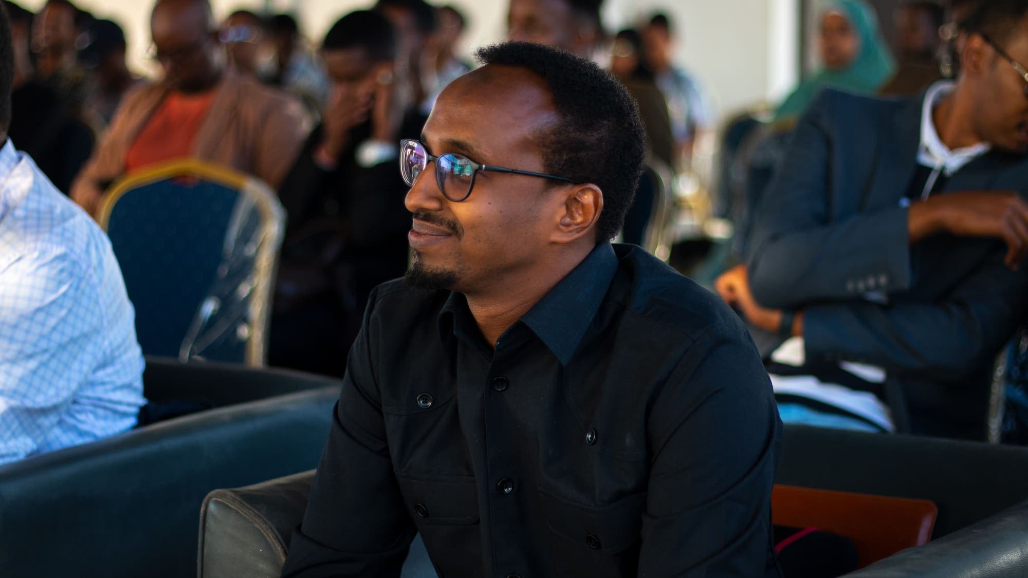 A man in the audience smiles during a session